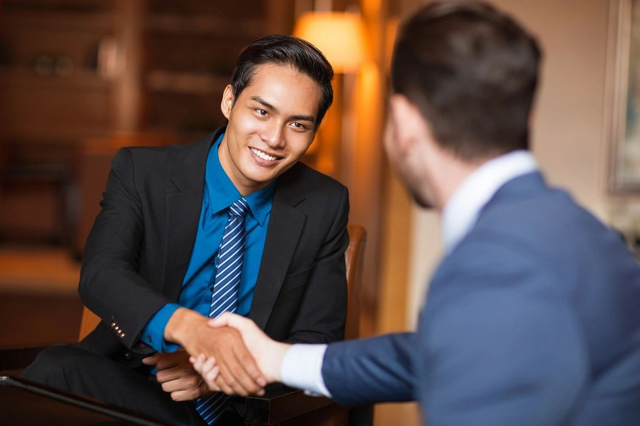 Two men shaking hands in a restaurant.