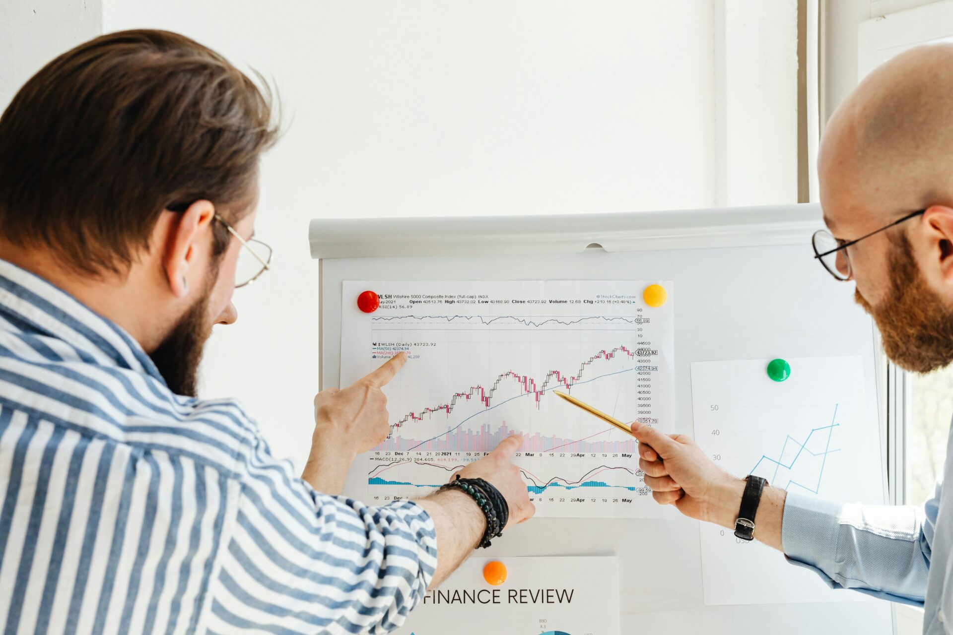 A man pointing to a chart on the wall